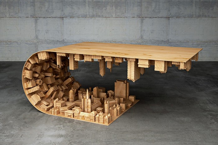 Stelios Mousarris, a Cyprus designer has realized the ‘wave city’ coffee table that bends a landscape of buildings in half.